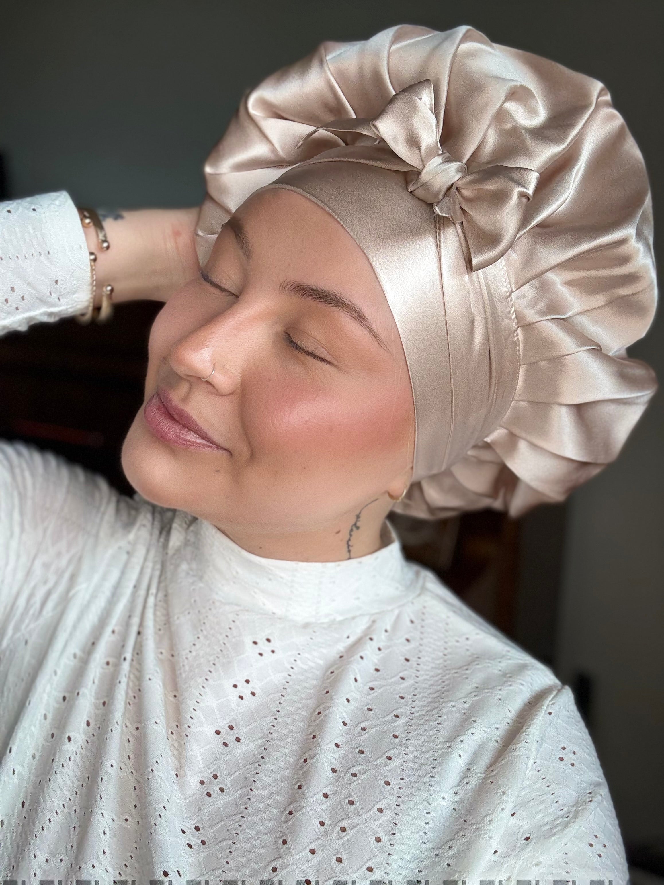 Blond ung kvinna som tar på sig en silkesbonnet i 100% mulberry-silke, mjukt och hudvänligt tyg, skyddar håret under sömn